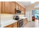 Well-lit kitchen with stainless steel appliances, quartz counters, and wood cabinets at 1910 Creekwater Blvd, Port Orange, FL 32128