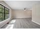 Spacious living room with large windows, wood-look floors, and a modern ceiling fan at 2032 Yorkshire Dr, Deland, FL 32724