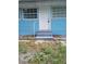 Charming blue house featuring a secure white door and freshly painted concrete steps at 20422 Canvas Back Rd, Altoona, FL 32702