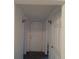 Well-lit hallway leading to a white door, enhanced by elegant wall sconces at 20422 Canvas Back Rd, Altoona, FL 32702