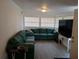 Inviting living room with a comfortable green sectional sofa and ample natural light at 20422 Canvas Back Rd, Altoona, FL 32702
