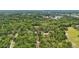 Expansive aerial view of a property surrounded by lush green trees and a beautiful lake in the distance at 2221 Oak Hill Dr, Deland, FL 32720