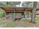 This barn features a wooden structure, open stalls, and green trim, blending functionality with rural charm at 2221 Oak Hill Dr, Deland, FL 32720