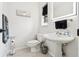 Well-lit bathroom with a pedestal sink, decorative art, and a modern, minimalist design at 2221 Oak Hill Dr, Deland, FL 32720
