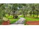 Scenic view of a long, winding driveway leading to a hidden estate, surrounded by lush greenery and mature trees at 2221 Oak Hill Dr, Deland, FL 32720