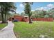 Exterior view of the home with a brick facade, walkway, and mature trees at 2221 Oak Hill Dr, Deland, FL 32720
