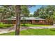 Charming single-story brick home with a metal roof, manicured lawn, and a welcoming entrance at 2221 Oak Hill Dr, Deland, FL 32720