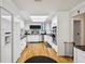 Bright white kitchen with stainless appliances and hardwood flooring at 2221 Oak Hill Dr, Deland, FL 32720