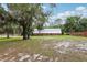Exterior of an outbuilding with a silver metal roof, brick facade, and a large lawn at 2221 Oak Hill Dr, Deland, FL 32720