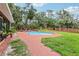 Backyard pool area with brick patio, landscaping, and mature trees at 2221 Oak Hill Dr, Deland, FL 32720