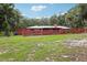 Brick home with fenced-in backyard and lawn surrounded by trees, offering privacy and charm at 2221 Oak Hill Dr, Deland, FL 32720
