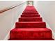 This features a staircase with red carpeting and a wooden banister along a white wall leading to an upper level at 2221 Oak Hill Dr, Deland, FL 32720