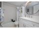 Clean bathroom featuring a shower-tub, a round mirror and a single sink vanity at 2222 Ocean Shore Blvd # 304B, Ormond Beach, FL 32176