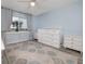 Well-lit bedroom with light blue walls, a large window and white furniture at 2222 Ocean Shore Blvd # 304B, Ormond Beach, FL 32176