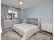 Cozy bedroom with a plush bed, large window and light blue walls with white trim and furniture at 2222 Ocean Shore Blvd # 304B, Ormond Beach, FL 32176