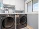 Bright laundry room with front-load washer and dryer, upper cabinets, and a window at 2222 Ocean Shore Blvd # 304B, Ormond Beach, FL 32176