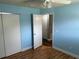This bedroom features wood floors, light-blue walls, a closet, and a ceiling fan at 233 Elmwood Ave # 290, Deland, FL 32724