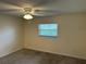 Cozy bedroom featuring carpet, a ceiling fan, and natural light from a window at 233 Elmwood Ave # 290, Deland, FL 32724