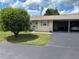 A cozy single-story home featuring a carport and a well-manicured front lawn on a sunny day at 233 Elmwood Ave # 290, Deland, FL 32724