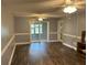 Spacious living room with wood floors, neutral walls, ceiling fans, and sliding glass doors at 233 Elmwood Ave # 290, Deland, FL 32724