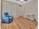 Bright bedroom with wood floors, ceiling fan, and comfortable blue chair at 241 Bayou Vista St, Debary, FL 32713