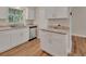 An additional angle of the bright kitchen featuring granite countertops and white cabinetry and wood flooring at 241 Bayou Vista St, Debary, FL 32713