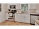 Bright kitchen features stainless steel appliances, granite countertops, white cabinetry, and wood flooring at 241 Bayou Vista St, Debary, FL 32713