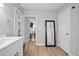 Contemporary bathroom with view into bedroom with tv, full length mirror, and wood laminate flooring at 2434 Barbarossa Ave, Deltona, FL 32738