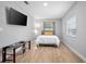 Clean bedroom with modern decor, sleek desk, minimalist lighting, and wood laminate flooring at 2434 Barbarossa Ave, Deltona, FL 32738