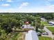 A home is nestled within lush foliage, featuring a fenced yard and multiple vehicles parked nearby, creating a serene, private setting at 2509 Kumquat Dr, Edgewater, FL 32141