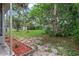 View of the backyard featuring green grass with a decorative border and plenty of space for activities at 2509 Kumquat Dr, Edgewater, FL 32141