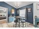 Dining room with a round table, complemented by modern lighting fixtures and stylish blue accent wall at 2509 Kumquat Dr, Edgewater, FL 32141
