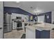 Stylish kitchen with stainless steel appliances, white cabinetry, and a breakfast bar perfect for casual dining at 2509 Kumquat Dr, Edgewater, FL 32141