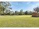 Expansive green backyard with mature trees, a small pond and a storage shed at 2699 Audubon Ave, Deland, FL 32720