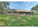 Expansive backyard view of brick home featuring screened-in porch and wooden deck at 2699 Audubon Ave, Deland, FL 32720