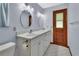 Bathroom boasts double sinks, a white vanity, and a medicine cabinet framed with designer mirrors at 2699 Audubon Ave, Deland, FL 32720