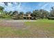 Ranch-style home with gravel driveway and mature trees, offering a private setting at 2699 Audubon Ave, Deland, FL 32720