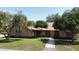 Classic brick house with a well-manicured front yard, mature trees and pathway to the entrance at 2699 Audubon Ave, Deland, FL 32720