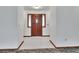 Inviting foyer with a striking wooden front door, transom window, and tile flooring at 2699 Audubon Ave, Deland, FL 32720