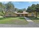 Charming single-story brick home with a well-manicured lawn, mature trees, and a stone pathway to the front door at 2699 Audubon Ave, Deland, FL 32720