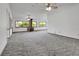 Expansive living room with multiple windows, a brick fireplace with a wood-burning stove, and plush carpeting at 2699 Audubon Ave, Deland, FL 32720