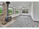 Bright living room with ample natural light from large windows and a cozy wood-burning stove at 2699 Audubon Ave, Deland, FL 32720
