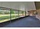 Enclosed porch with view of expansive lawn, featuring dark flooring, screen walls, and an exterior access door at 2699 Audubon Ave, Deland, FL 32720