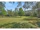 Expansive property with lush greenery, mature trees, pond and gated entrance under a bright blue sky at 2699 Audubon Ave, Deland, FL 32720