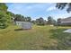 Extensive backyard with lush green grass, a storage shed, mature trees, and a frisbee golf basket at 272 Sunrise Blvd, Debary, FL 32713