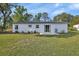 Exterior backyard showing well-maintained lawn, partial fence, and freshly painted white house at 272 Sunrise Blvd, Debary, FL 32713