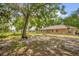 Large backyard featuring partial chainlink fence, grassy area, and partial shade under a large oak tree at 2885 Newmark Dr, Deltona, FL 32738