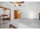 A well-lit bedroom featuring a queen-sized bed, carpet floors, a ceiling fan, and a mirrored sliding door closet at 2885 Newmark Dr, Deltona, FL 32738