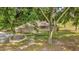 Scenic view showcases the home surrounded by mature trees and green lawn at 2885 Newmark Dr, Deltona, FL 32738
