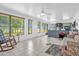 Spacious living room with tile flooring, ceiling fan, and large windows offering natural light and backyard views at 2885 Newmark Dr, Deltona, FL 32738